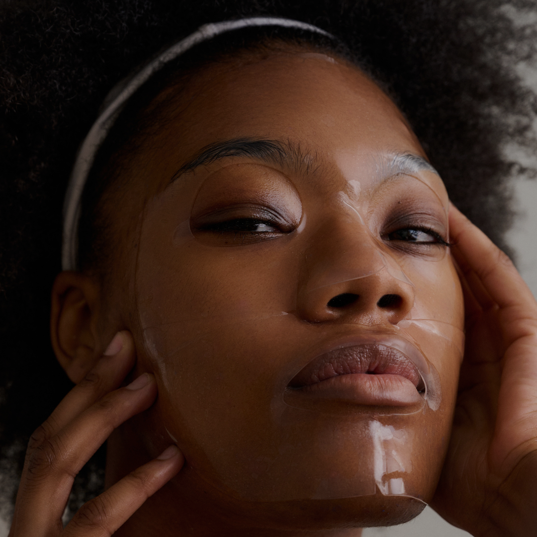 Woman applying a skincare product to her face with a close-up view.