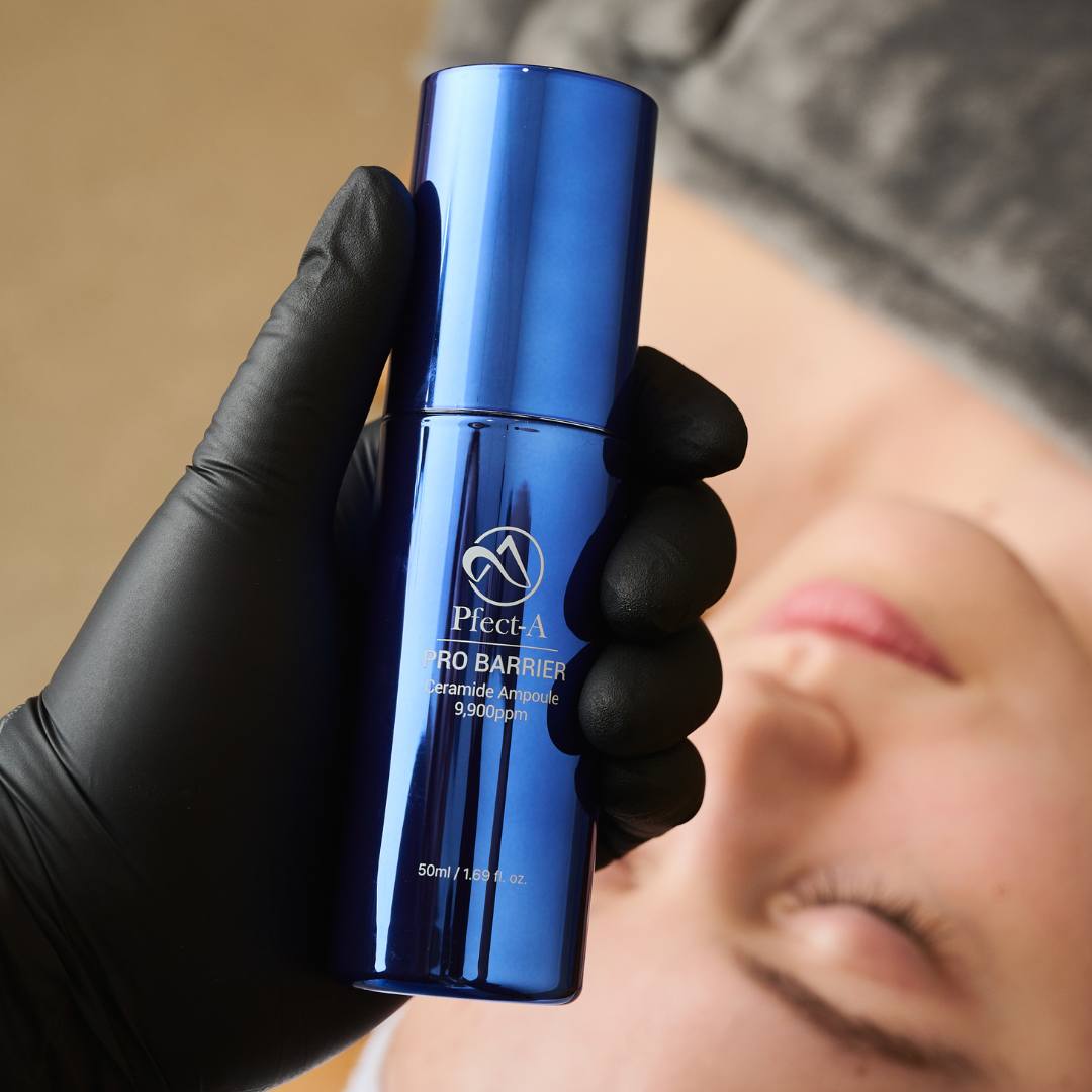 hand holding blue skincare product above a face